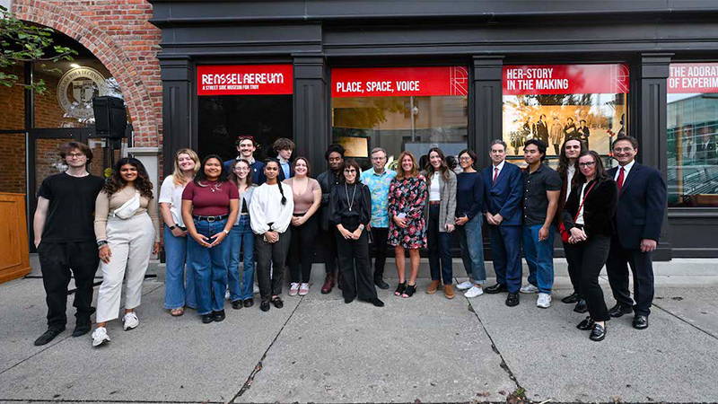 A group of people stand in front of an exhibit display