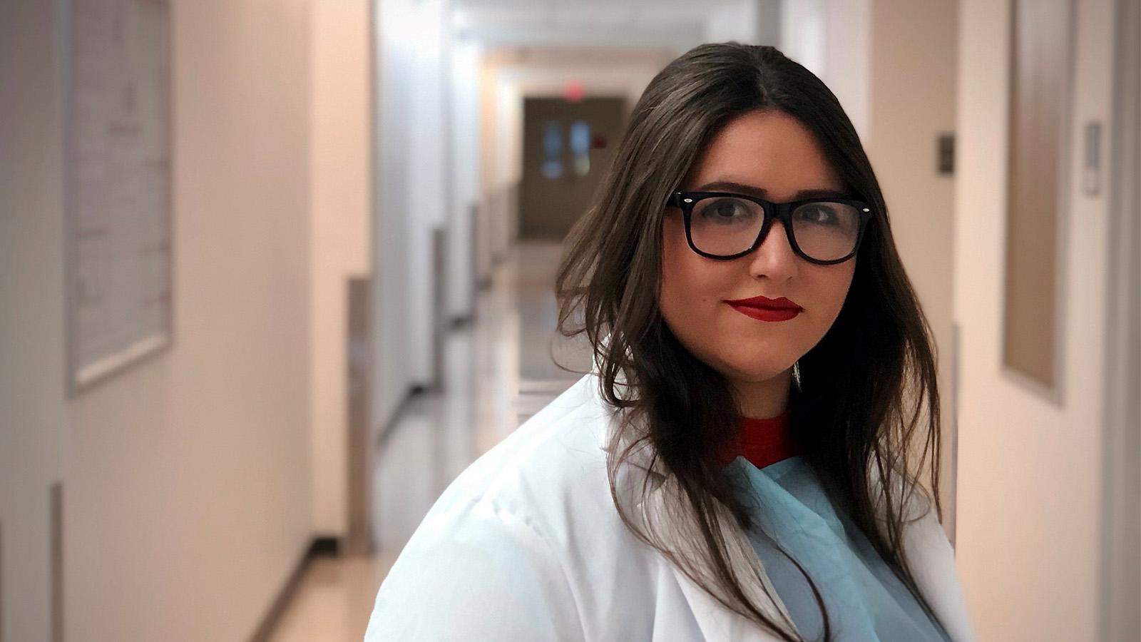 Young woman in lab coat in a hallway