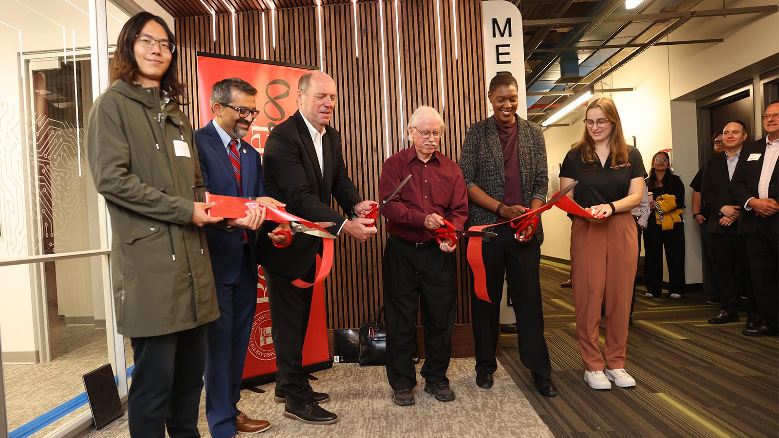 Six people lined up to cut a ribbon