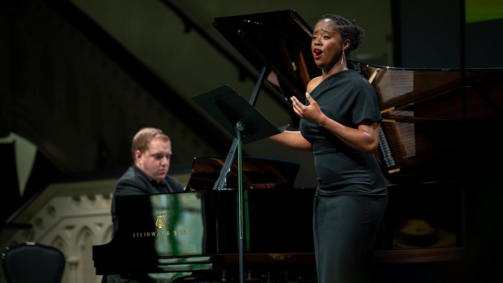 A woman singing accompanied by a pianist