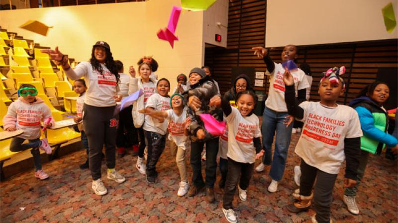 Children test paper airplanes they have designed at Black Families Technology Awareness Day.