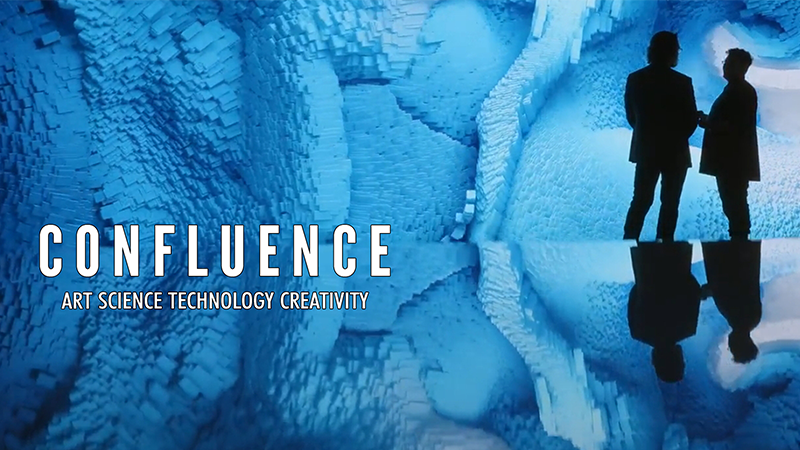 Two people stand in a cavernous space with walls that appear to be composed of intricate, crystalline structures in shades of blue. The word "CONFLUENCE" is prominently displayed in the foreground, along with the subtitle "ART SCIENCE TECHNOLOGY CREATIVITY" below it, suggesting a thematic focus on the intersection of these disciplines. The image evokes a sense of exploration and innovation.