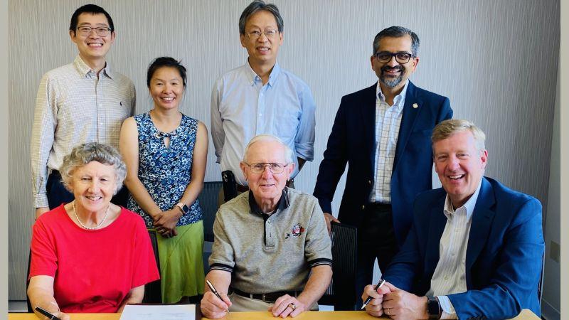 Seated at a wooden table signing documents: Joan and Rich Felak and Matt TerMolen Standing behind the seated group: Zheyu Zhang (Felak Fellow), Lucy Zhang, John Wen, and Shekhar Garde