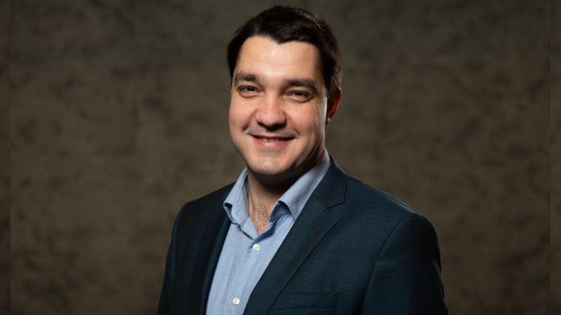 Professional headshot of Rado Ivanov from the chest up smiling in a blue suit.