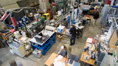 Overhead view of manufacturing and and prototyping equipment with people walking between