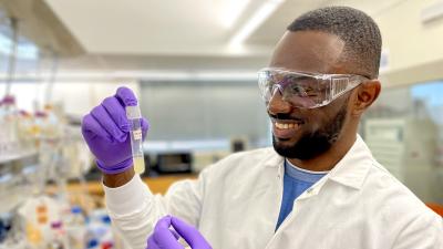 Young scientist looks at a vial of liquid in the lab