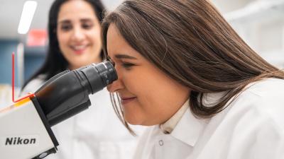 Woman looks through microscrope